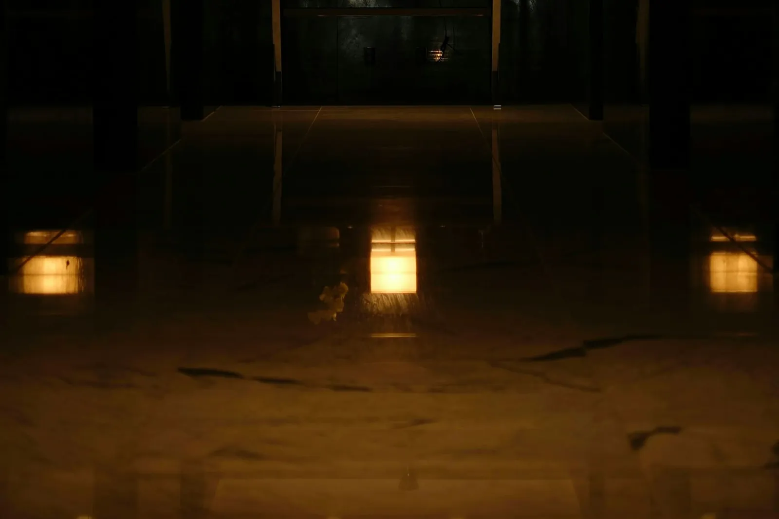 Dunkle Hotellobby mit warm leuchtenden Tischlampen