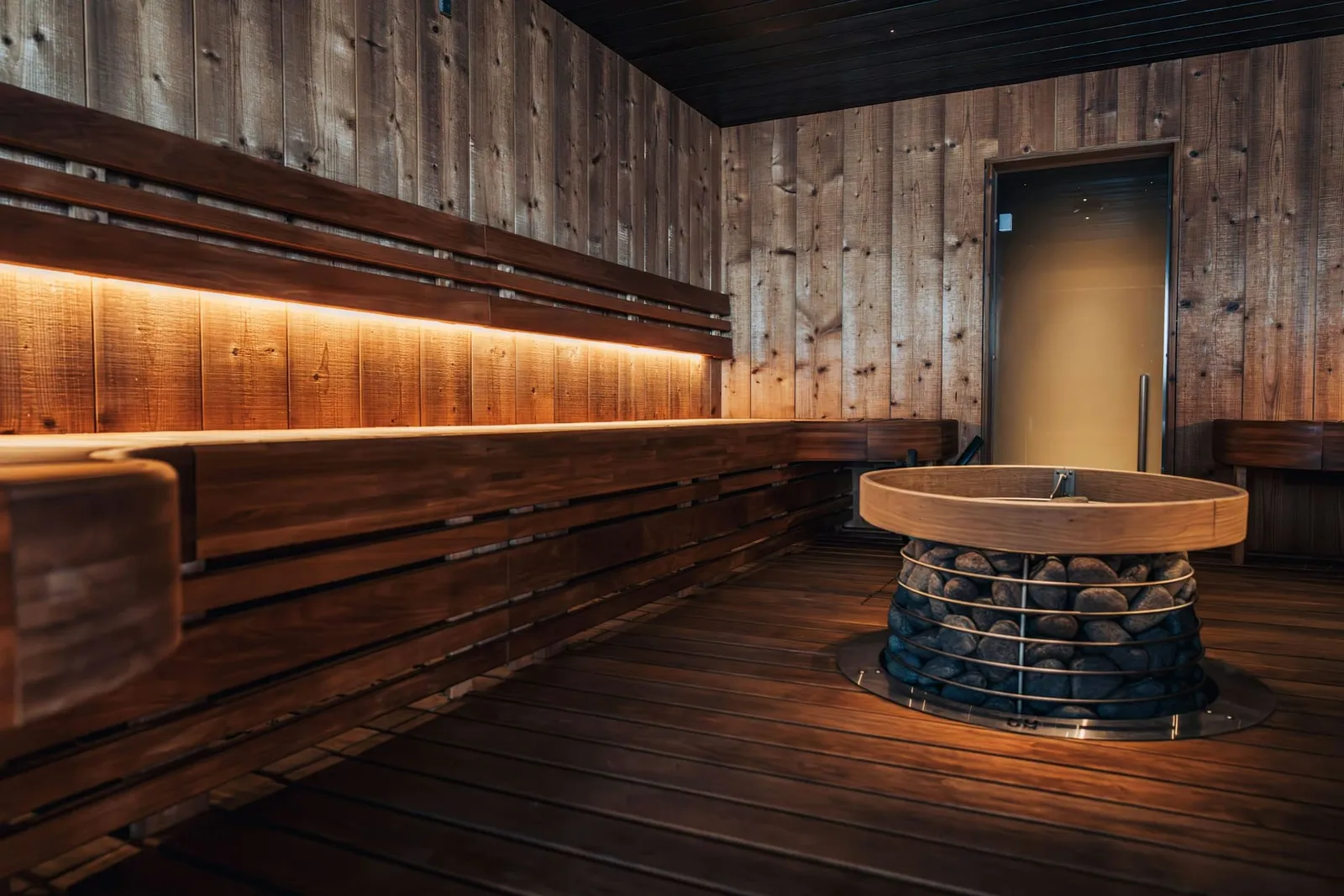 Leere Sauna mit warmer indirekter Beleuchtung und Saunaofen