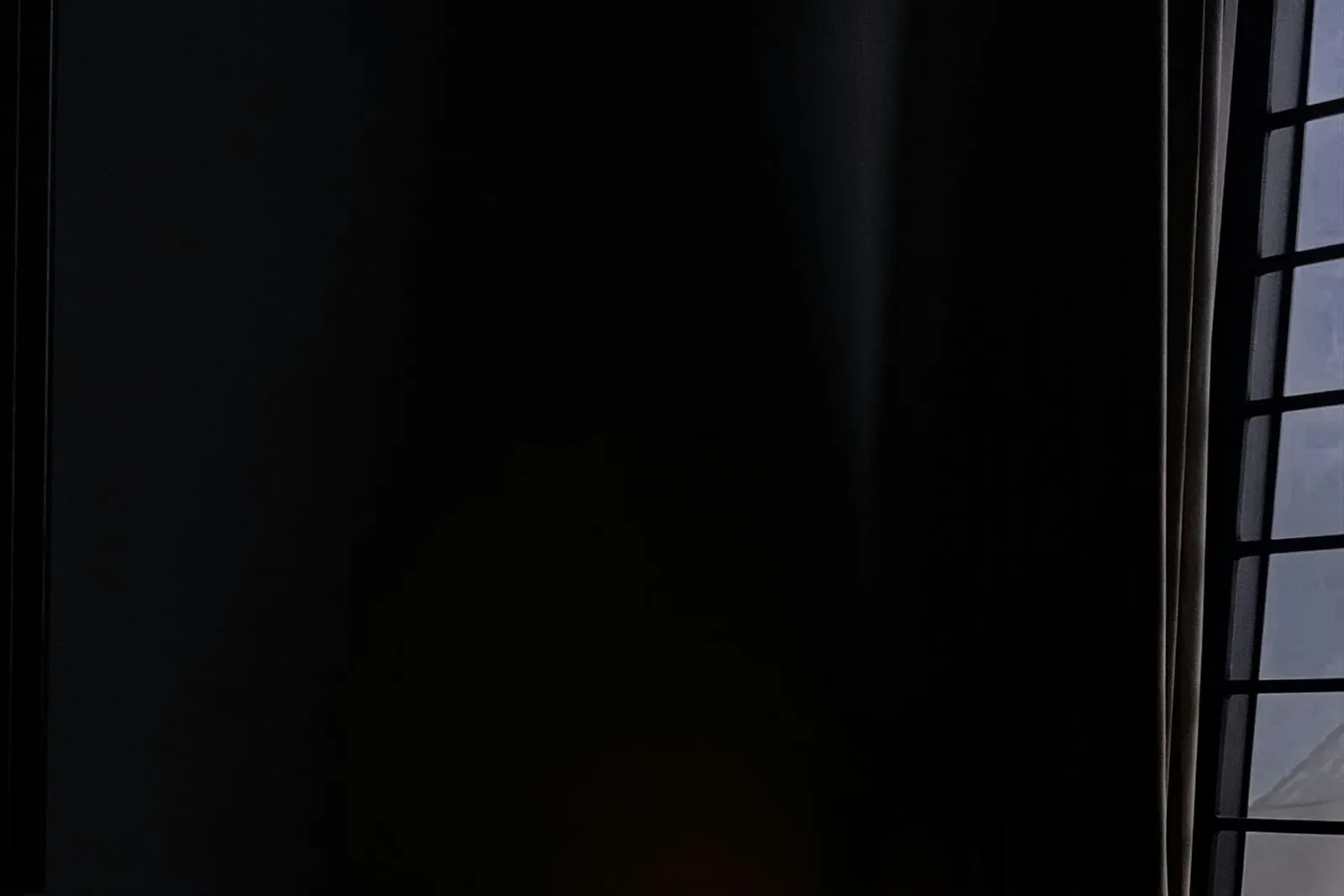 Laptop und Schreibtischlampe in einem dunklen Zimmer
