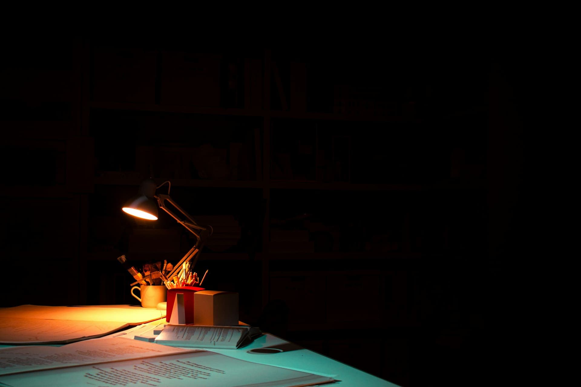 Schreibtisch mit Lampe in einem dunklen Raum