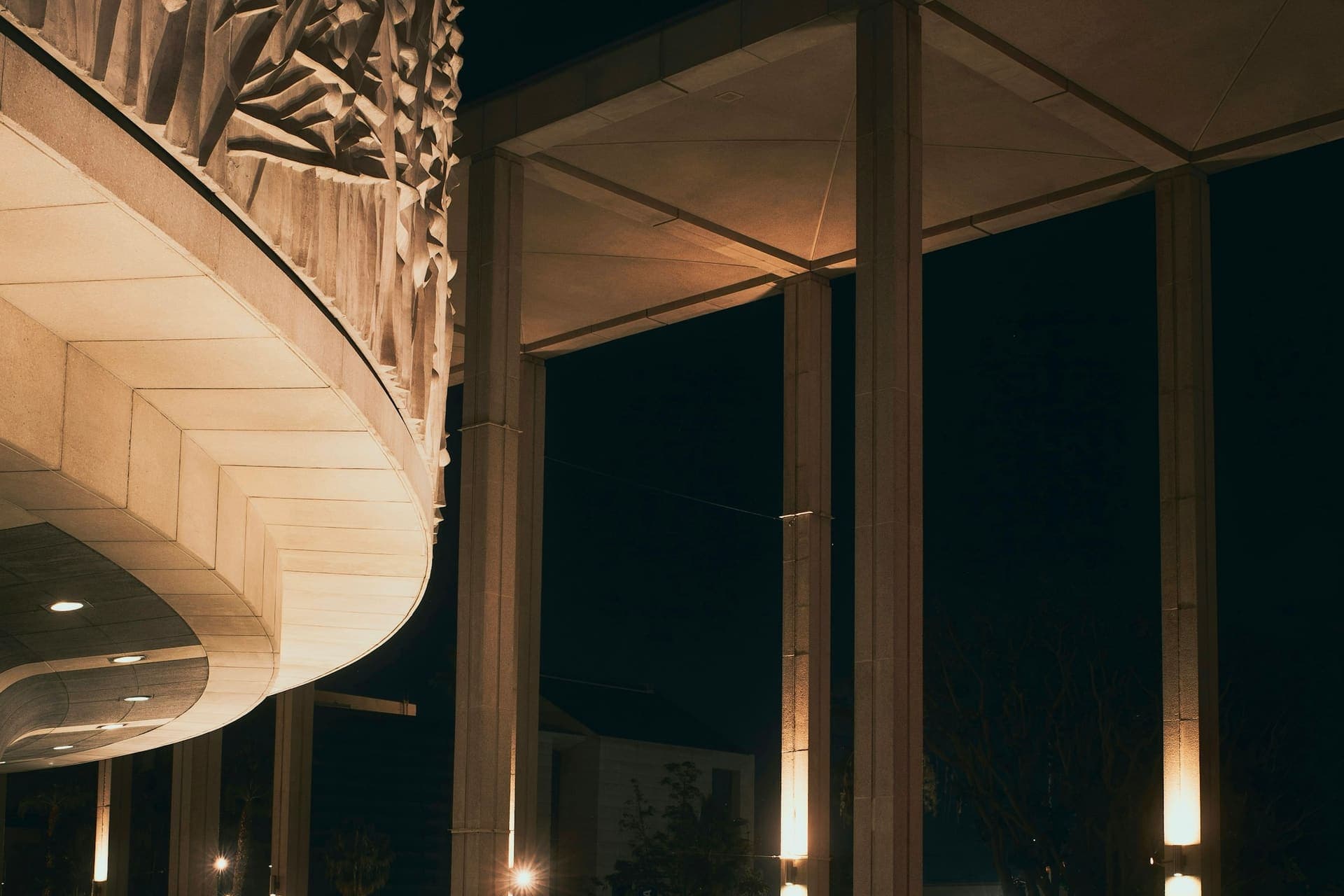 Dunkles Hallenbad mit warm beleuchteten Säulen bei Nacht