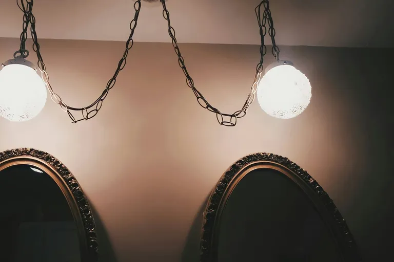 Zwei Leuchten über ornamentierten Rundbogen