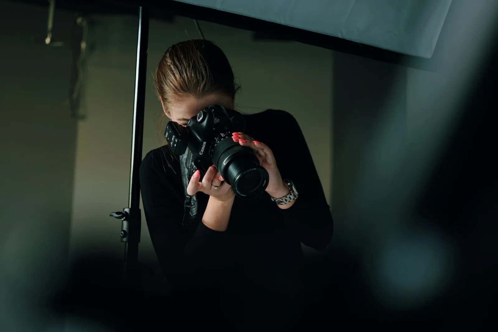 Fotografin mit Kamera in einem abgedunkelten Studio