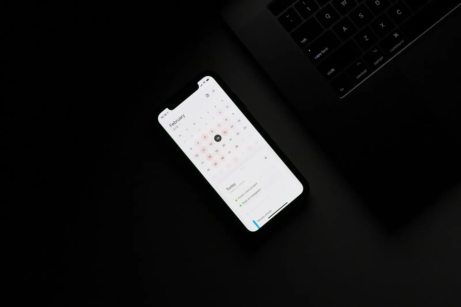 Smartphone mit Kalender auf einem dunklen Tisch