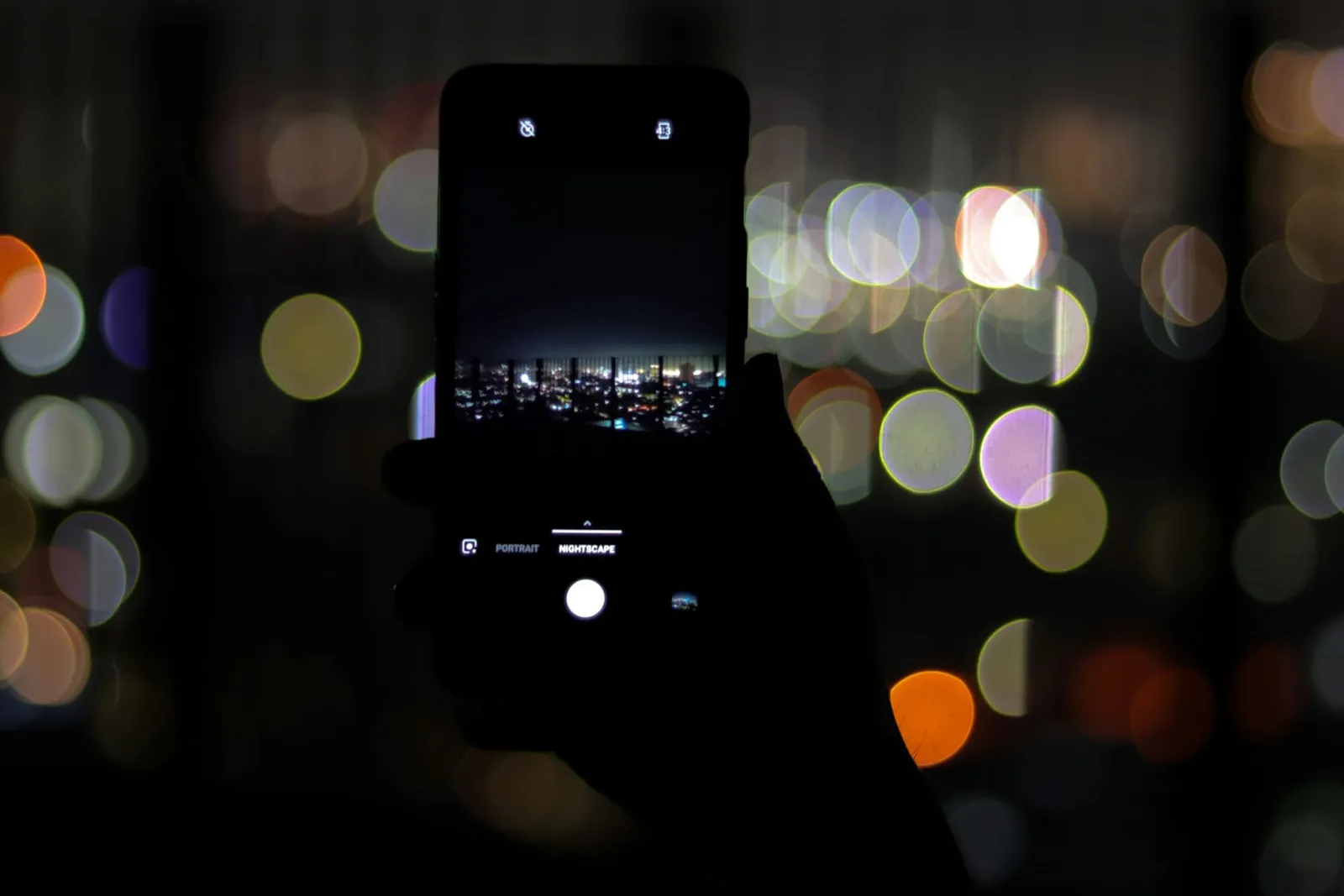 Smartphone vor nächtlichen Lichtern