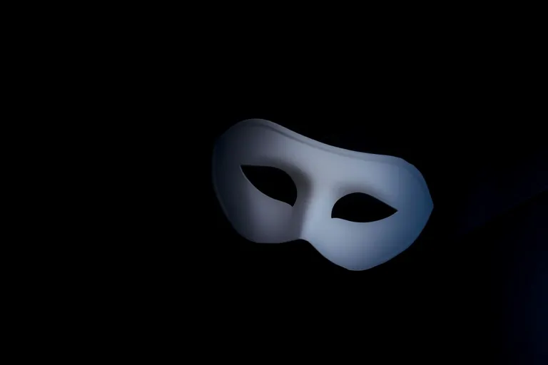 Schlichte weiße Maske vor schwarzem Hintergrund