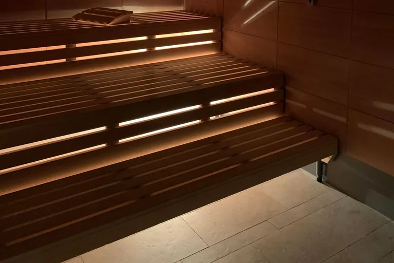Sauna mit Lichtstreifen unter den Holzbänken