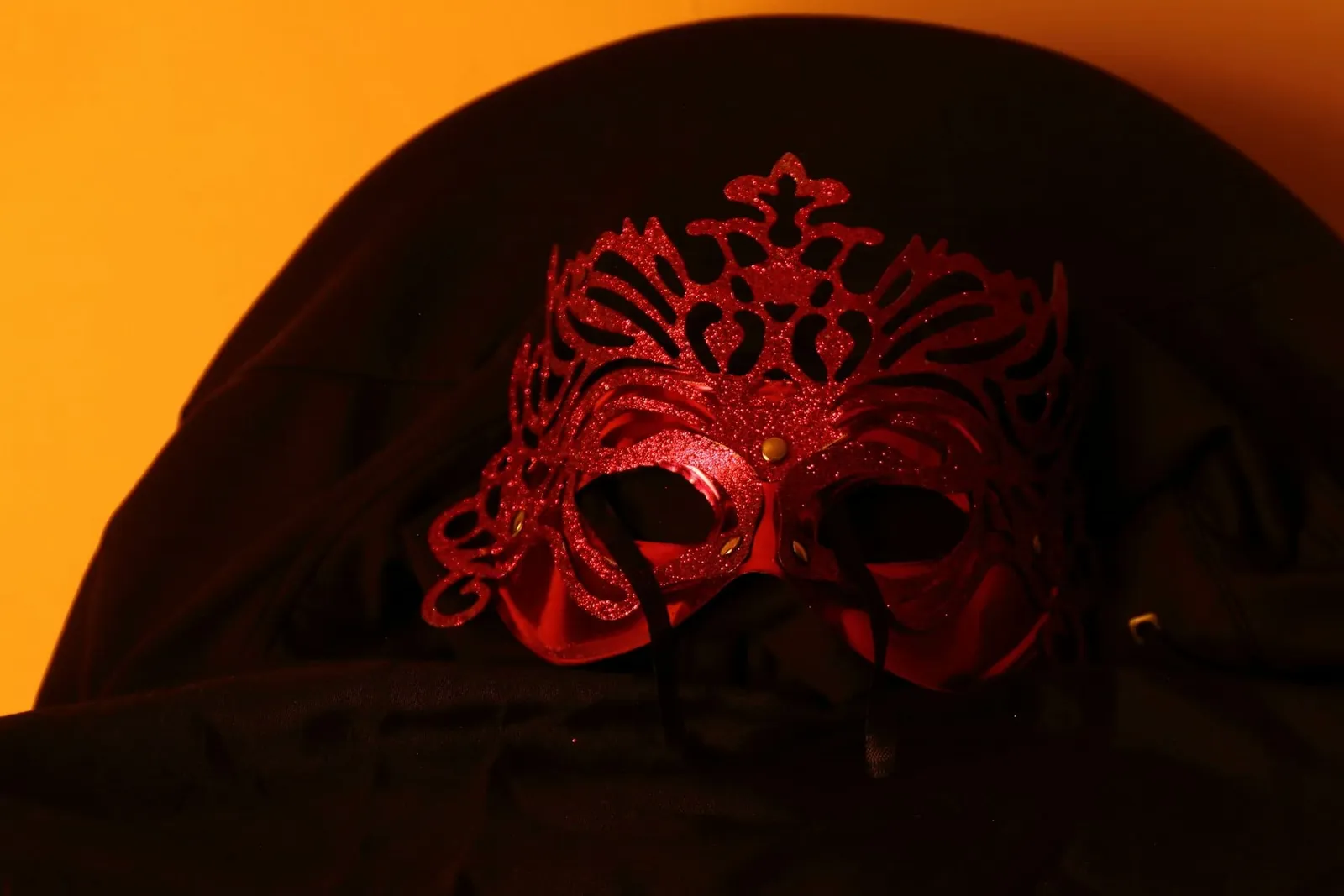 Rote Spitzenmaske auf dunklem Stoff