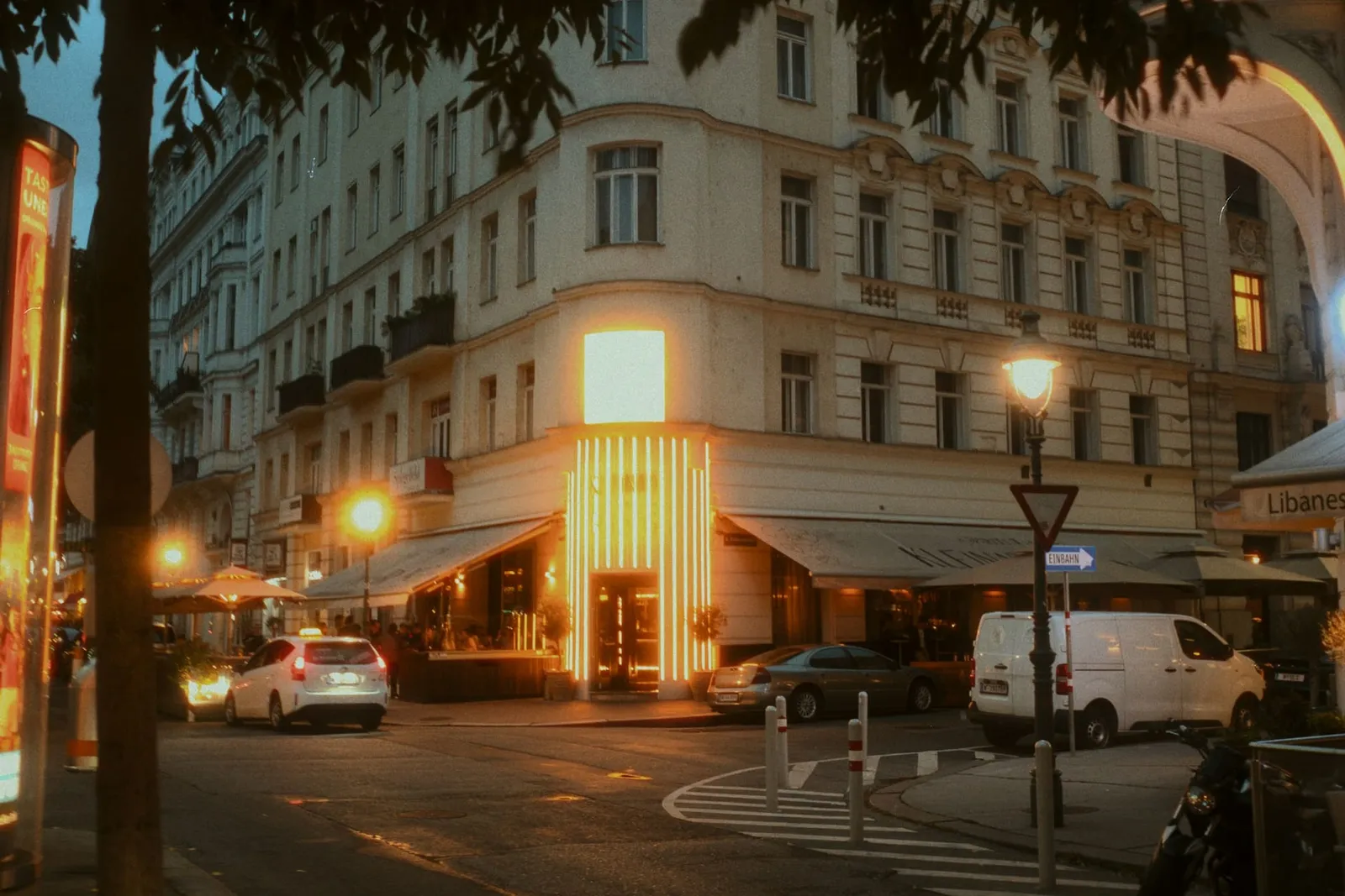 Straßenecke in Wien bei Nacht mit beleuchteter Fassade