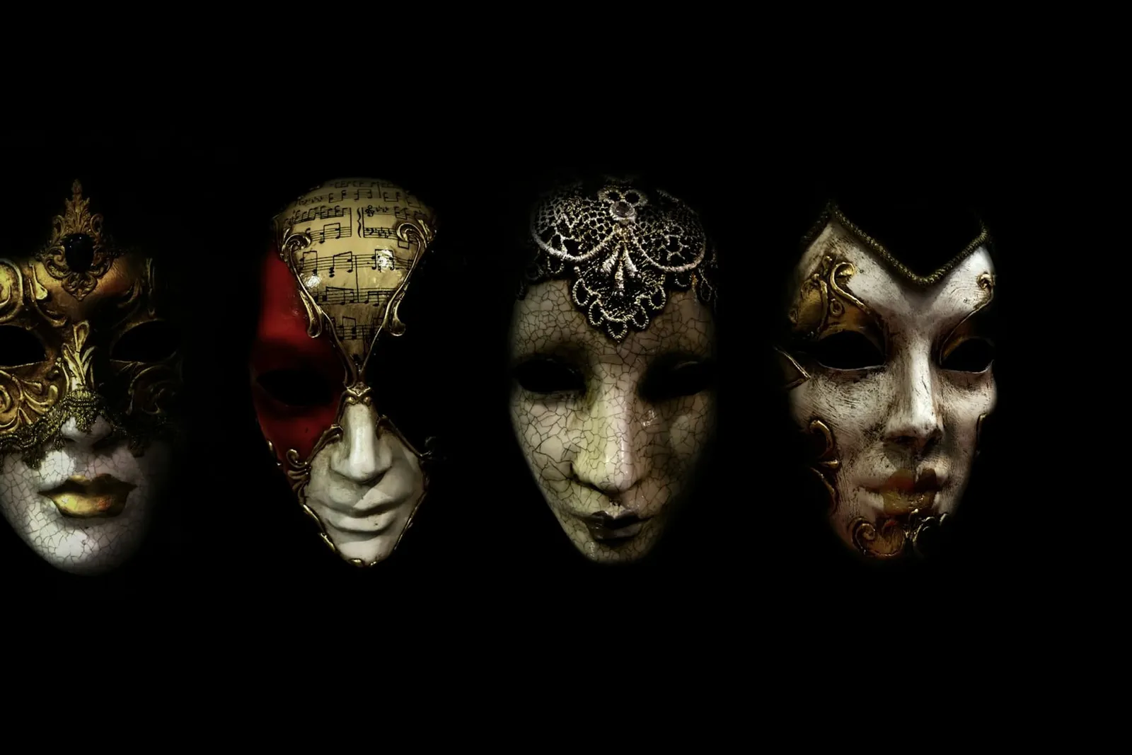 Reihe venezianischer Masken vor schwarzem Hintergrund