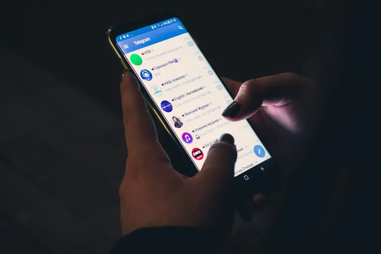 Hände halten ein Smartphone mit geöffneter Messenger-App
