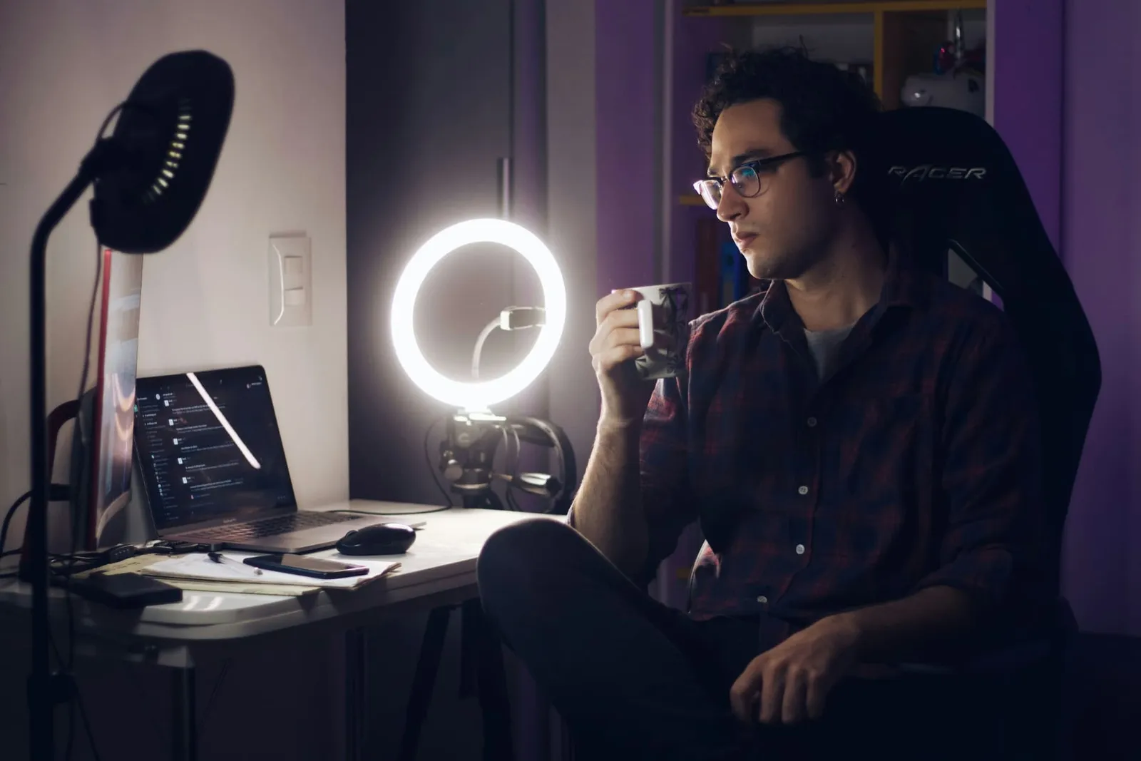 Streamer an einem Schreibtisch mit Ringlicht und Monitor