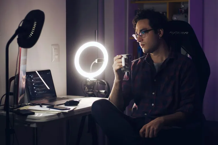 Streamer an einem Schreibtisch mit Ringlicht und Monitor