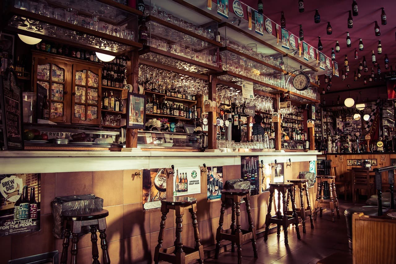 Leerer Clubraum vor der Öffnung mit dunklem Samtsofa und Messingdetails an der Bar
