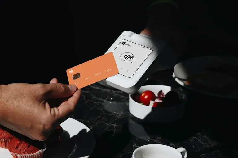 Karte wird an ein Bezahlterminal gehalten